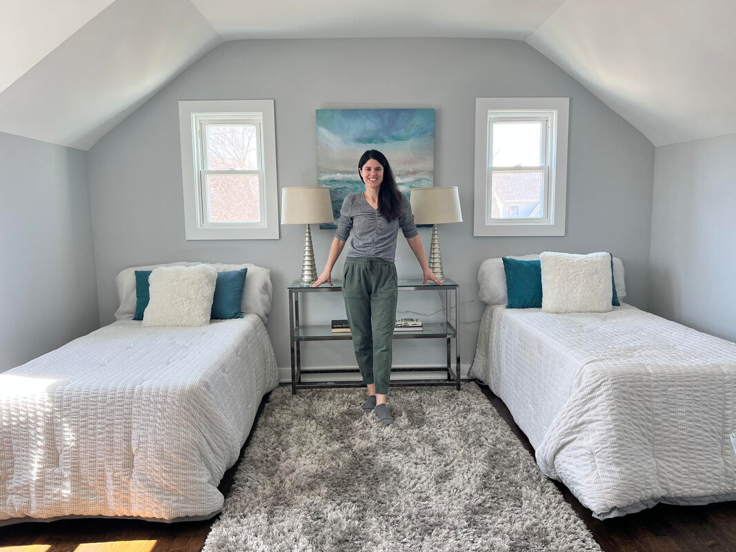 Home Stager Ashley showcases a beautifully staged bedroom with two twin beds for optimal space usage and appeal to potential buyers